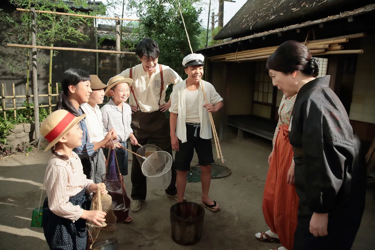 第22回より。散歩に出掛けた萬平(長谷川博己)は、川で魚取りをしている子どもたちに遭遇し、一緒に魚を捕まえることに