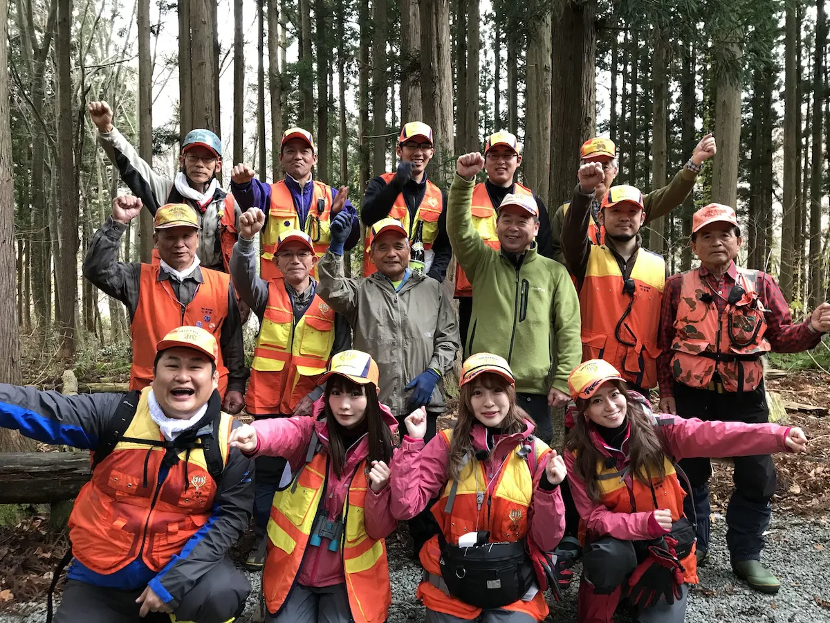 番組の進行役を務めるオテンキ・のり(左下)と、山形県小国町のマタギの方たちと記念ショット