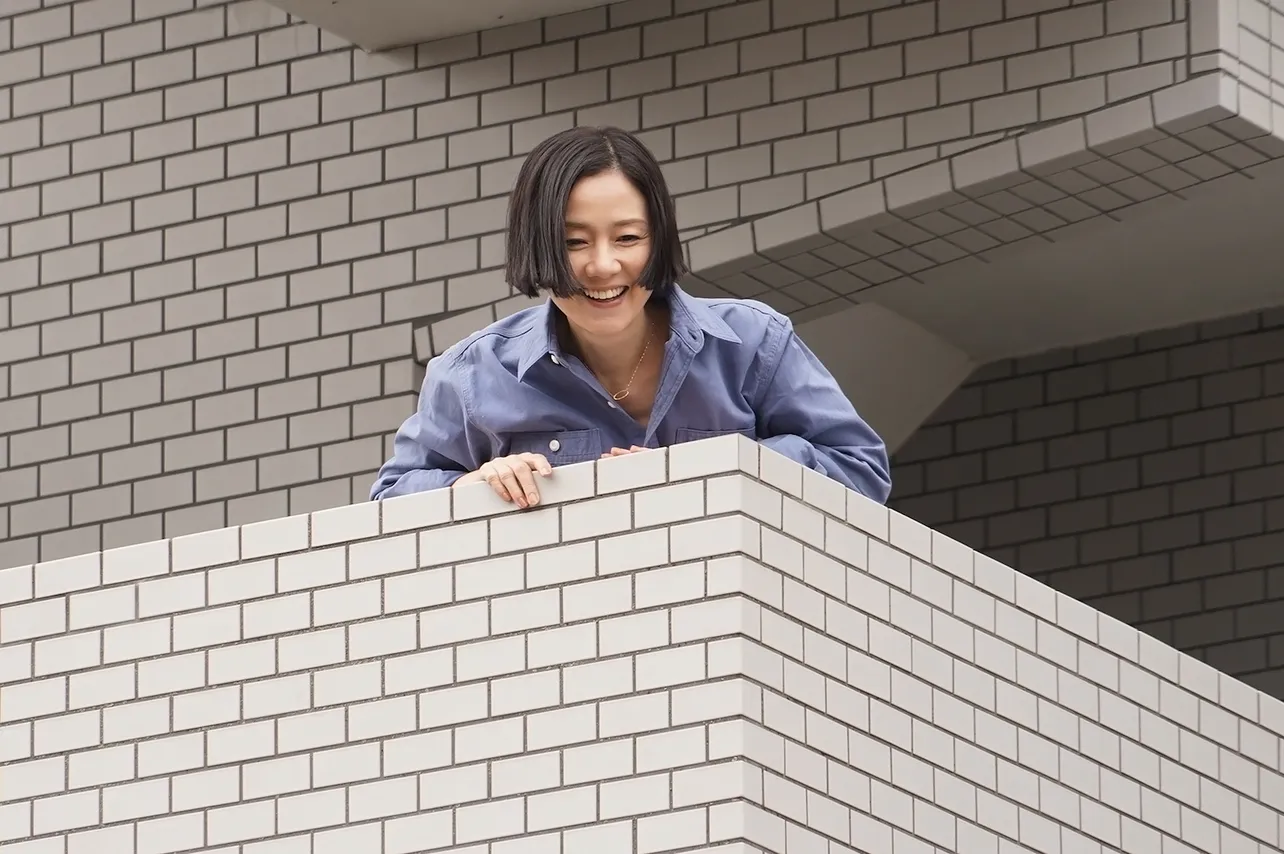 【写真を見る】原田知世がマンションの外階段から、下にいる田中圭に財布を投げるシーンを撮影した