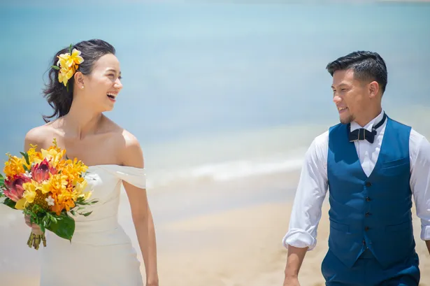 【写真を見る】ハワイのビーチで幸せの笑顔を交わす卜部弘嵩・高橋ユウ夫妻