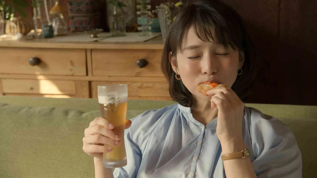 新・一番搾りTVCMに出演する石田ゆり子(5)。ビールを飲んでおつまみをパクッ