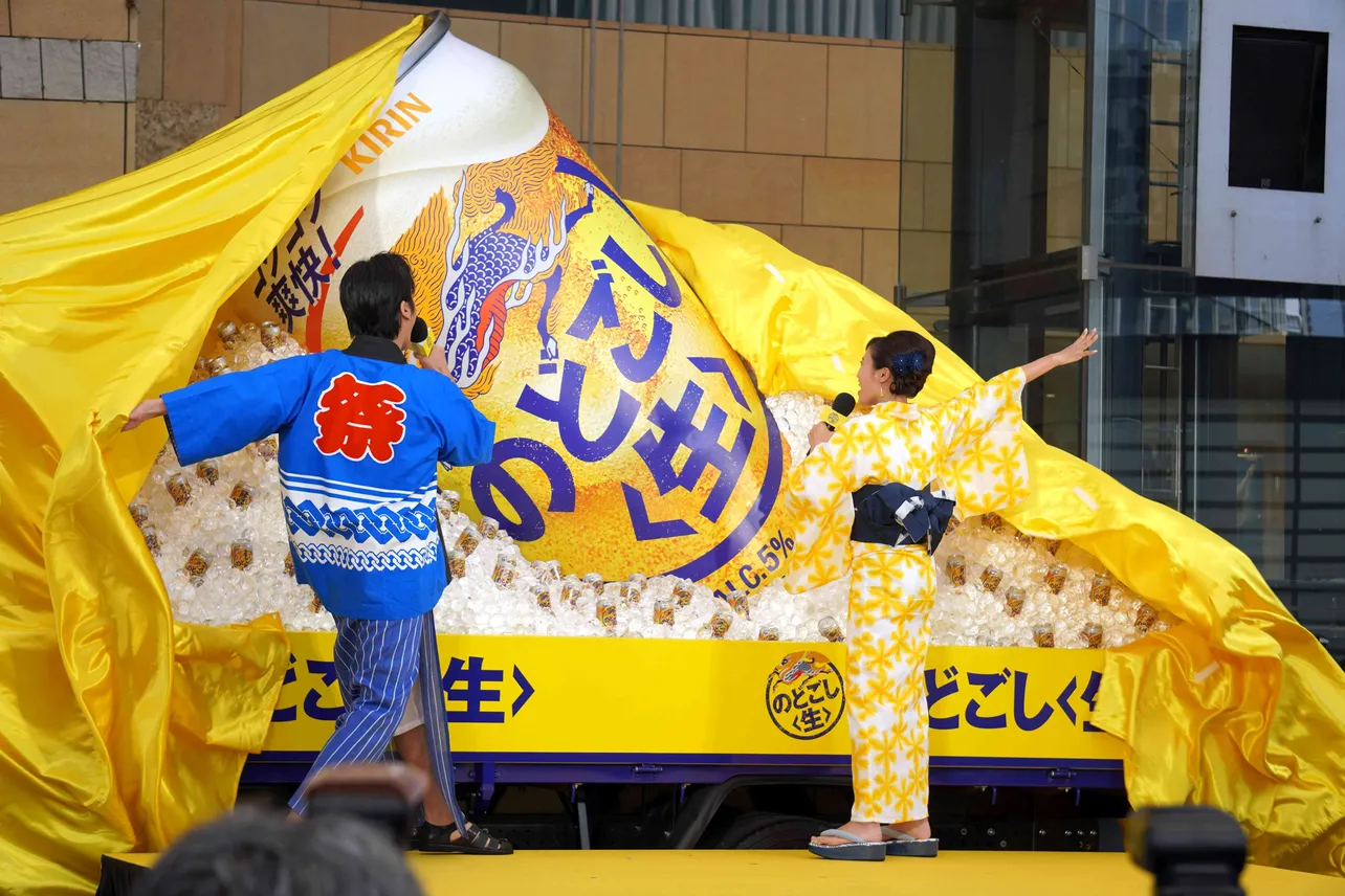 桐谷健太と小島瑠璃子が除幕するとトラックに積まれたビールと氷の山が現れる