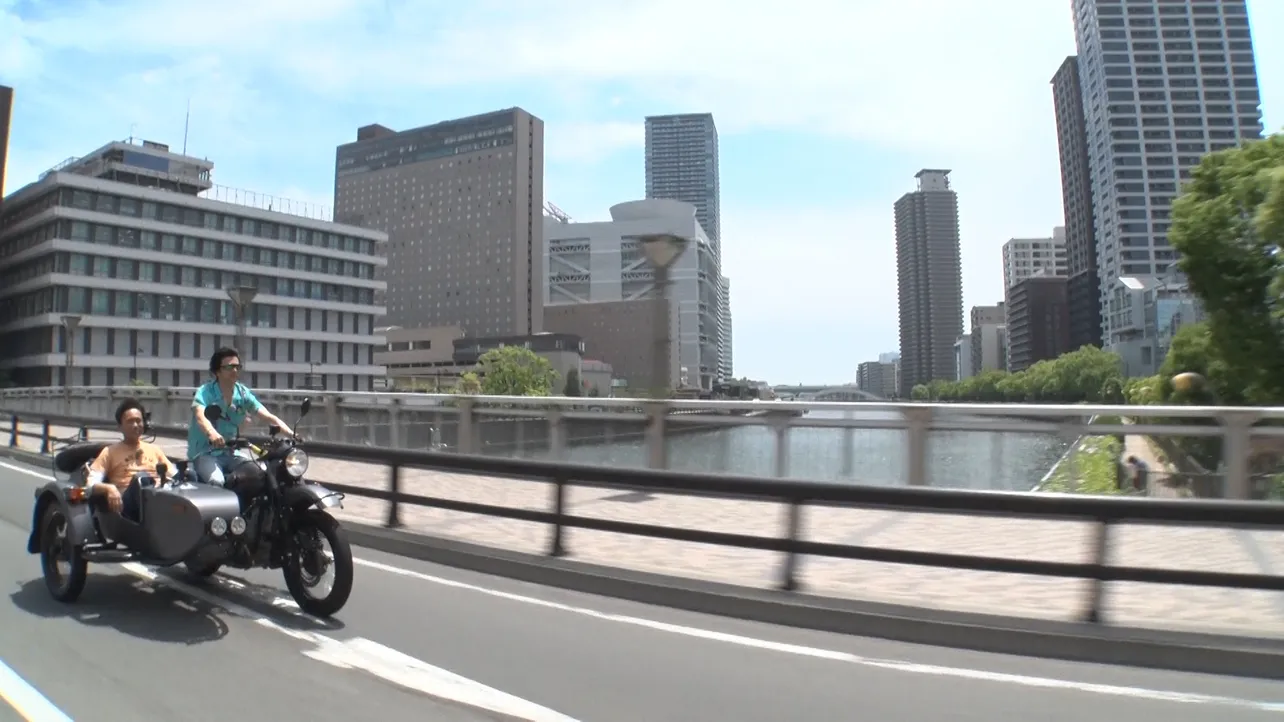 武田が浜田をサイドカーに乗せて大阪の街を疾走