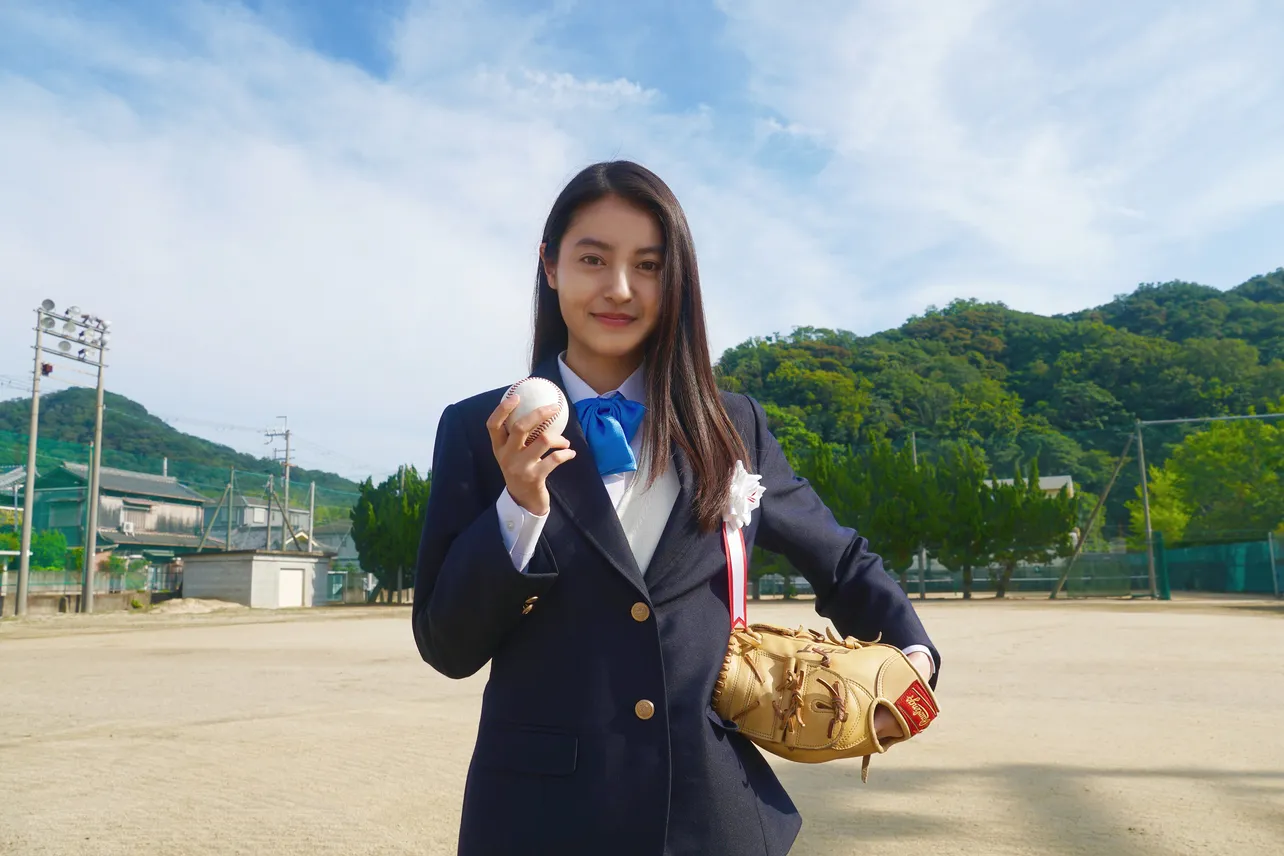 【写真を見る】女性高校生の制服に身を包み、笑顔でボールを握る田辺桃子