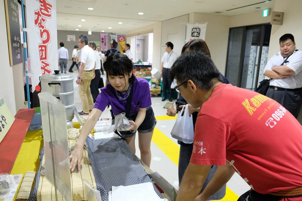 【写真を見る】即売所で「熊本いきなり団子」の販売を手伝う井上