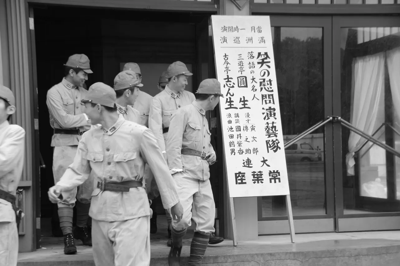 志ん生と圓生の看板を笑顔で見つめる人々