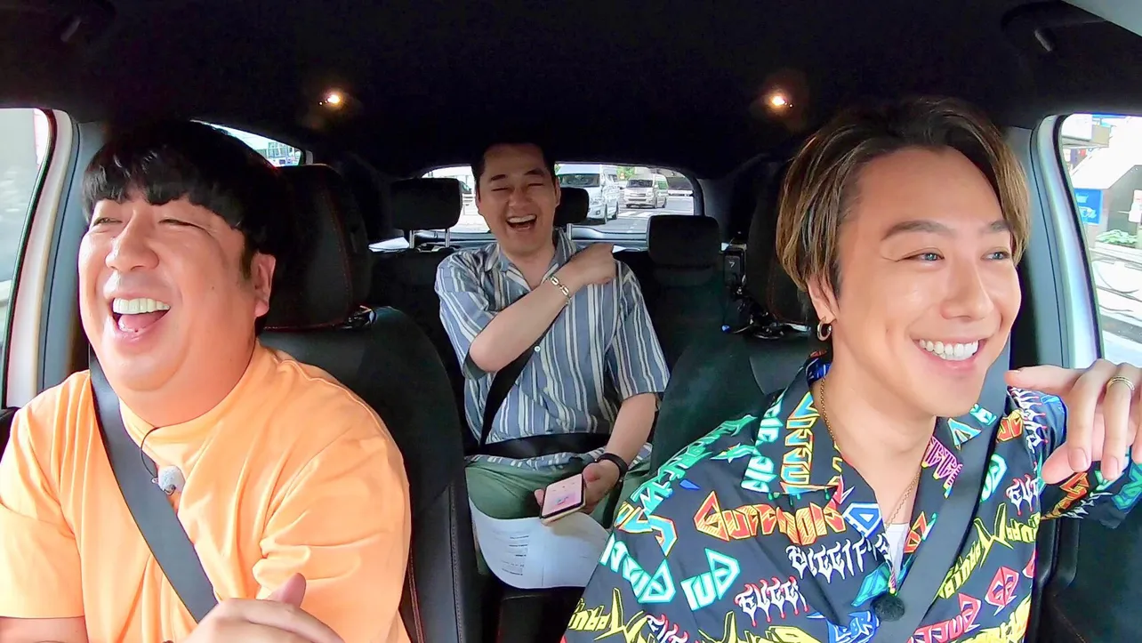 【写真を見る】ドライブ中の車内では、クイズ「サビ前ドン！」にも挑戦！　楽しそうに笑顔を見せる3人