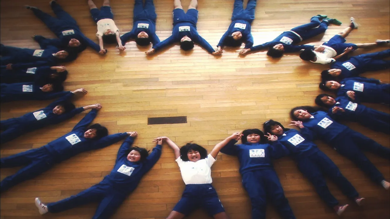 【写真を見る】小学校の教室で撮影された“21人の輪”