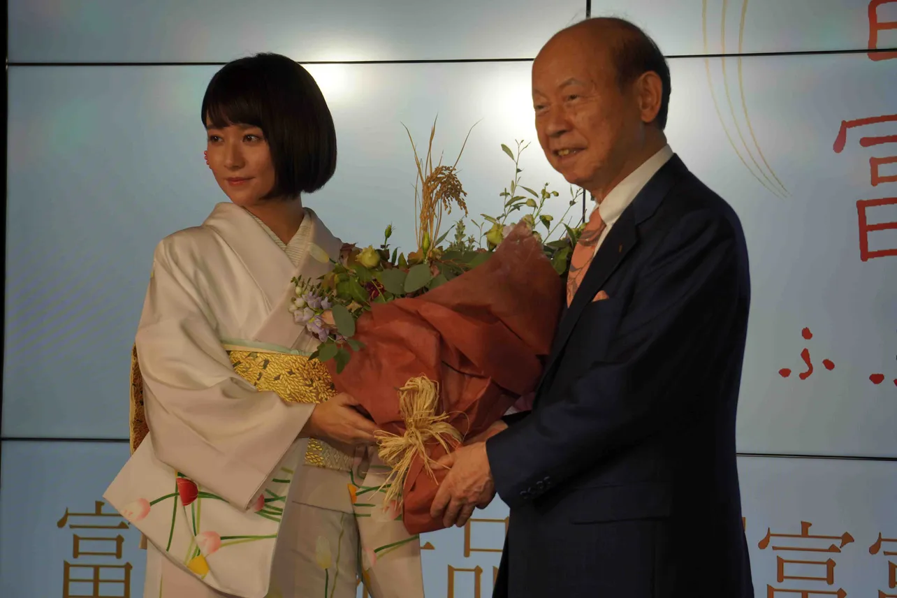 稲穂が使われた花束を贈られた木村文乃。右は石井隆一富山県知事