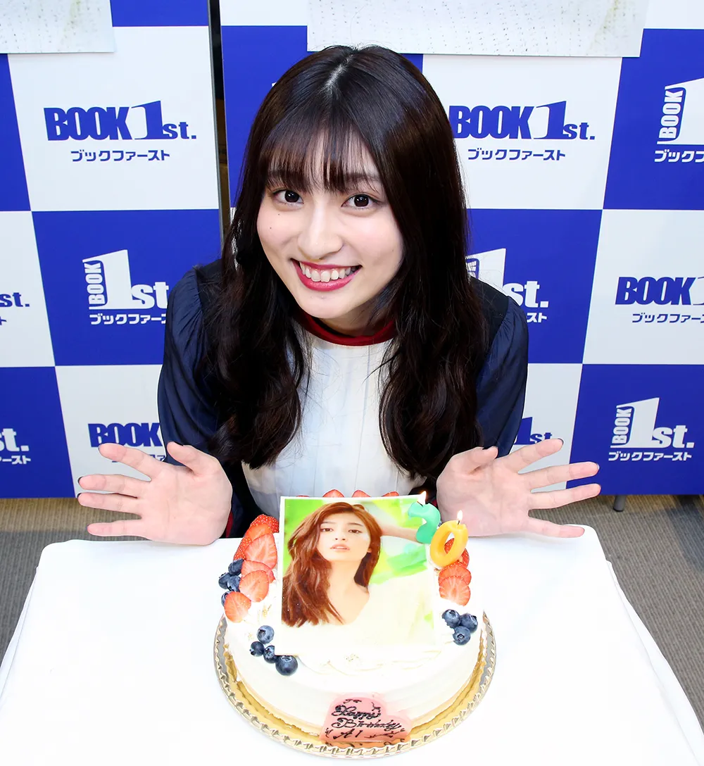写真集の表紙写真を使ったケーキを前に笑顔を見せる吉川愛