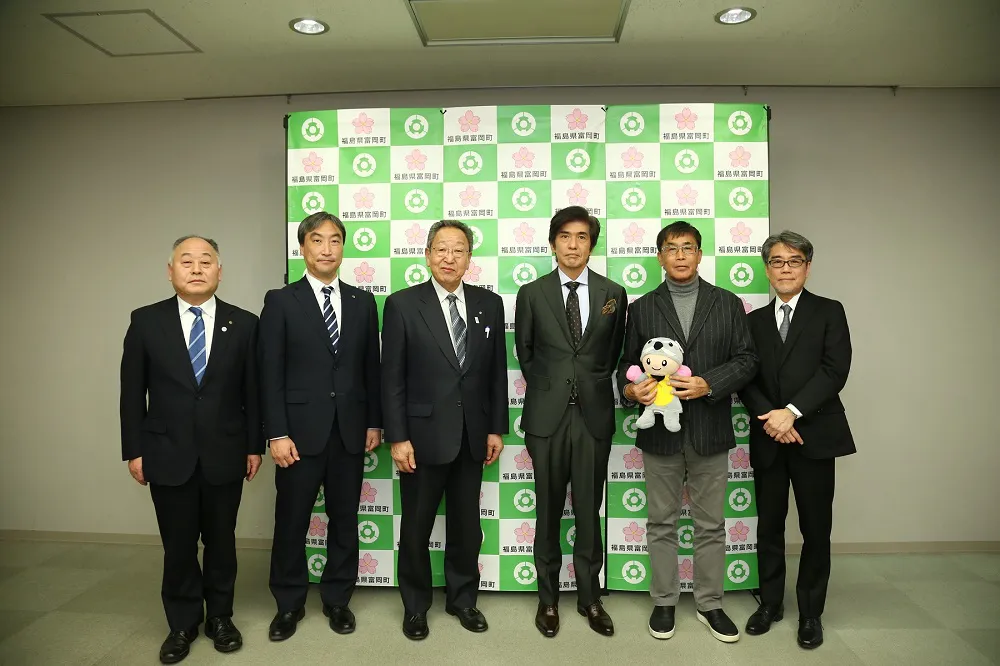 【写真を見る】富岡町役場を表敬訪問した佐藤浩市と若松節朗監督