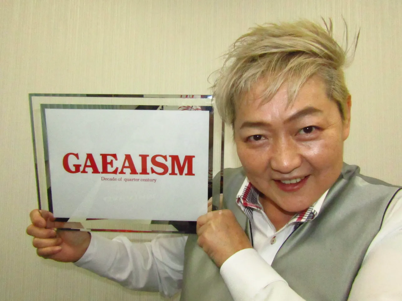 【写真を見る】「 GAEAISM」のボードを掲げる長与千種