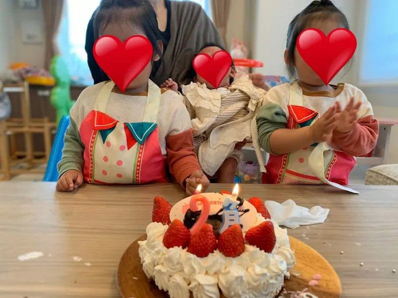 【写真を見る】双子の娘たちの手作りケーキとママに抱っこされている三女