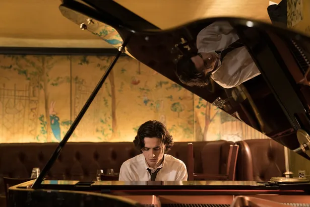 【写真を見る】ウディ・アレン監督も常宿にしているというホテル「カーライル」にある「ベメルマンズ・バー」でピアノを弾くティモシー・シャラメ