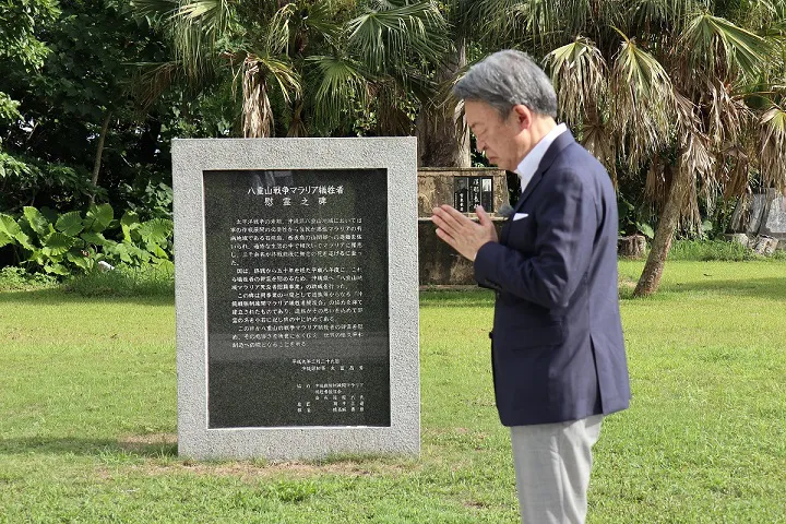 【写真を見る】沖縄・八重山諸島で「戦争マラリア」の現場を取材する　池上の隣には石碑が立っている