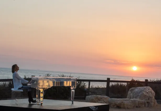 【写真を見る】YOSHIKIは、アメリカ・ロサンゼルス郊外にある海岸から、美しい夕日をバックに「Forever Love」を演奏