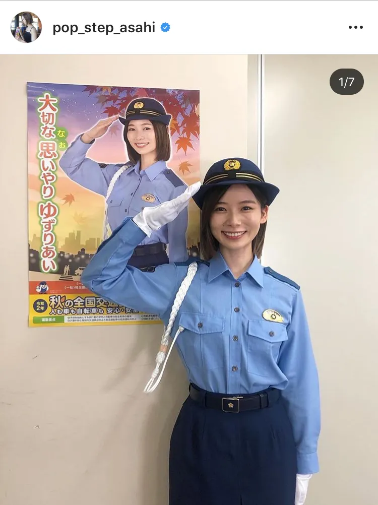 【写真を見る】自身のポスターの前で、笑顔で敬礼をする制服姿の朝日奈央