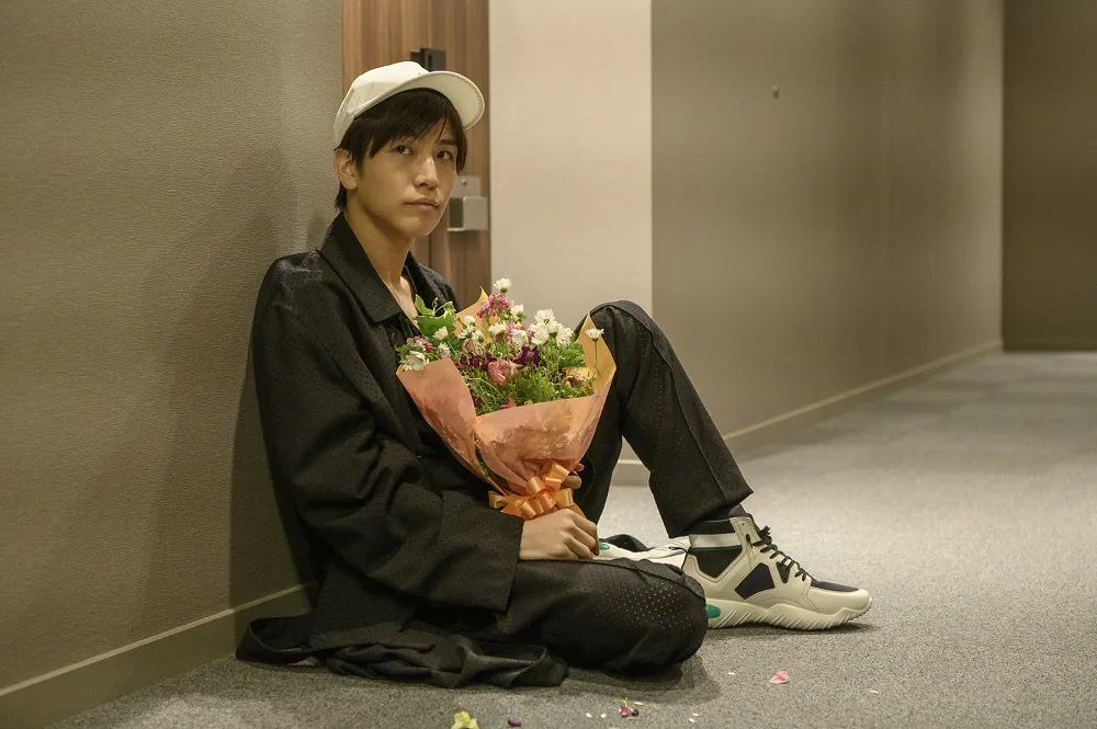 【写真を見る】岩田剛典が、花束を抱えて部屋の前で帰りを待つ姿も