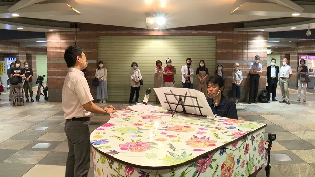 【写真を見る】街角で奏でられる音楽に、行き交う人が耳を傾ける