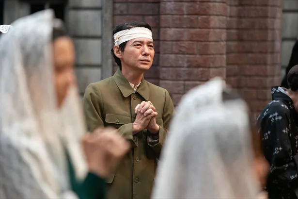 【写真を見る】国民服姿で頭に包帯を巻き、祈りを捧げる永田医師(吉岡秀隆)。表情には悲しみがにじむ