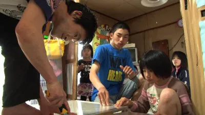 父親の作業をジッと見つめる子供たち