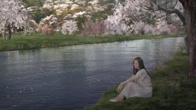 サクラが咲く川辺にたたずむ中谷