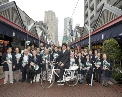 糸村の代名詞でもある自転車に乗ってポーズを決める上川隆也と月島の皆さん