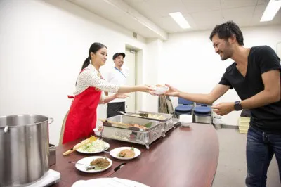 武井がスタッフに夜食を手渡し。男性スタッフは恐縮しながらも笑顔がこぼれる