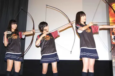 弓矢でくす玉を割る乃木坂46の桜井玲香、生駒里奈、生田絵梨花(写真左から)