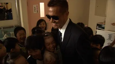 【写真】母校の小学校の式典を訪れ、子供たちに囲まれるATSUSHI