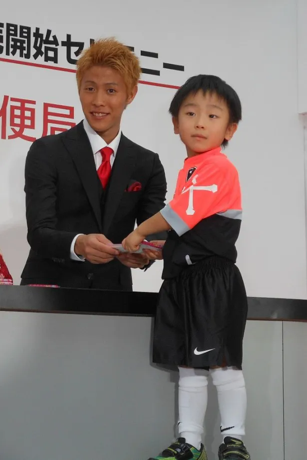 サッカー好きの少年に年賀状を手渡す柿谷選手