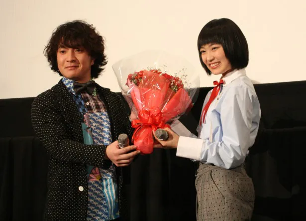 高校受験に合格した柏木(右)にサプライズで花束を贈る濱田(左)