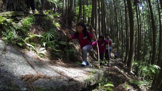普段は叱咤激励する立場の松岡ですら弱気になりかける急な山道を登る子供たち