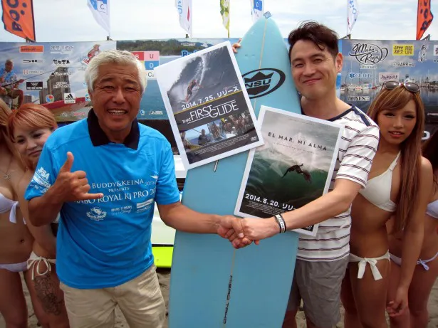 【写真を見る】辻堂海岸で行われたサーフィンの大会の主催者・MOBO氏（写真左)と握手を交わすスギ。