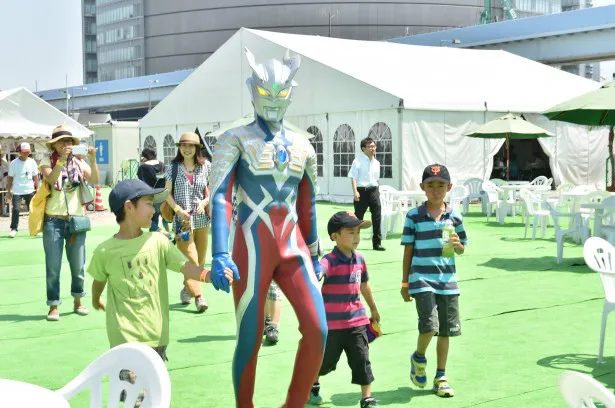 ウルトラマンゼロと手をつないで会場を歩く子供たち