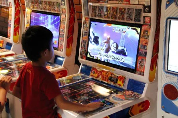 【写真を見る】会場に設置された「マジンボーン」のアーケードゲームで遊ぶ子供たち。「マジンボーン」は小中学生に人気だ