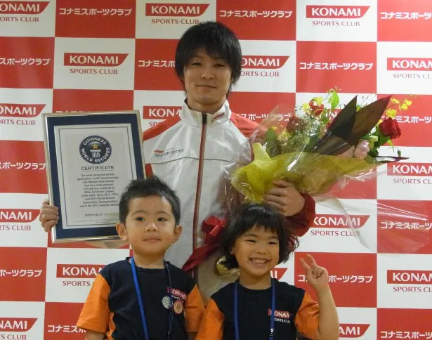 コナミスポーツクラブ長崎に通う今村葵ちゃん（前列右）、中村圭吾くん（前列左）からギネス認定証と花束を授与された内村選手
