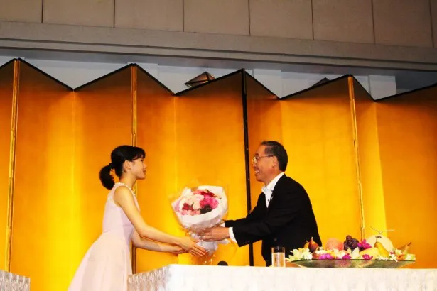 【写真を見る】第一園芸株式会社の植草慶一氏から花束を贈呈される土屋