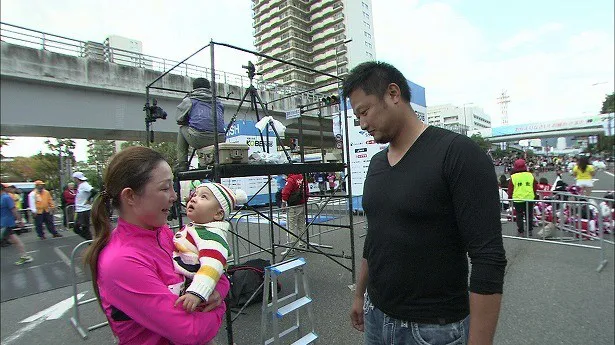 マラソン当日、息子の誠希千(せいきち)くんを抱く小原正子と、二人を見詰めるマック鈴木