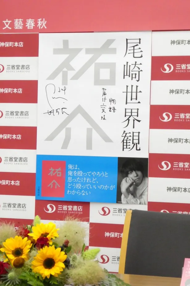 【写真を見る】「届け変な物語」という尾崎の直筆のサインが入ったポスター