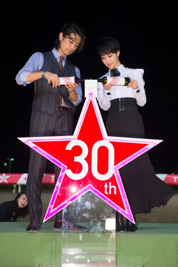 【写真を見る】斎藤＆剛力が、仲良く30周年を記念して作られた光るオブジェにシャンパンを注ぐ